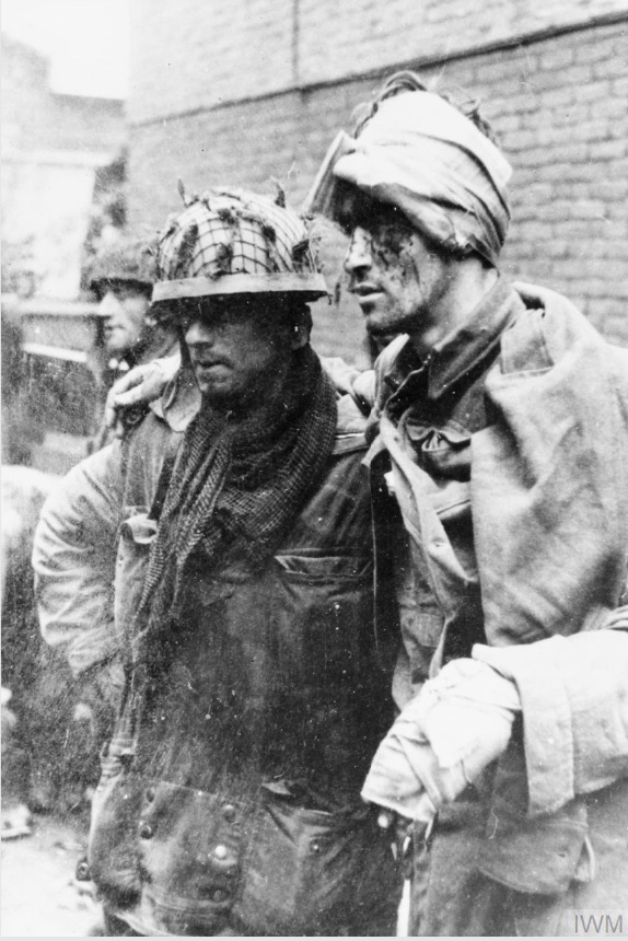 On This Day: 17th September 1944 THE BRITISH AIRBORNE DIVISION AT ARNHEM AND OOSTERBEEK IN HOLLAND

An Allied paratrooper assisting a wounded comrade. This photograph was taken at around 3.30pm east of the Arnhem main road bridge. From left to right. Sapper J Dunney, Sapper C Grier and Lance Corporal R Robb, all of the 1st Parachute Squadron, Royal Engineers. The men had just been shelled and burnt out of the van Lunburgstirum school which they had occupied since the evening of the 17 September. © IWM (HU 2131)